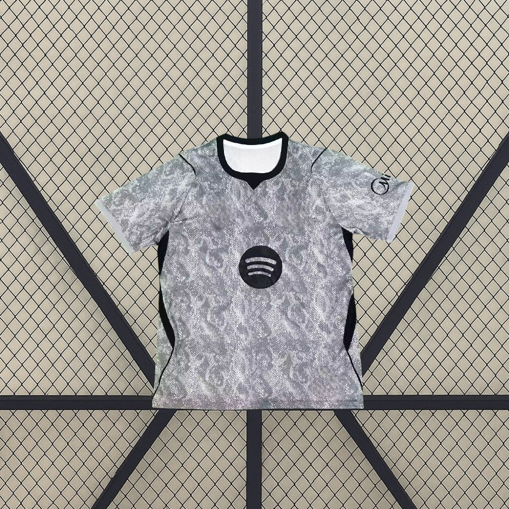 Camiseta Barcelona 26-27 portero gris vista frontal con estampado tonal, cuello negro y paneles laterales oscuros