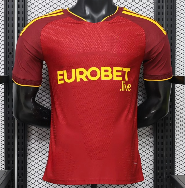 Camiseta Roma 26-27 local Player vista frontal en rojo con mangas oscuras, detalles amarillos y tejido técnico texturizado