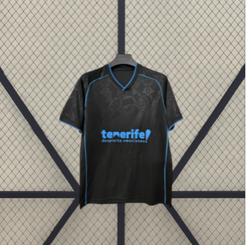 Camiseta Tenerife 26-27 visitante vista frontal desplegada en negro con patrón tonal y detalles azul turquesa en cuello y mangas