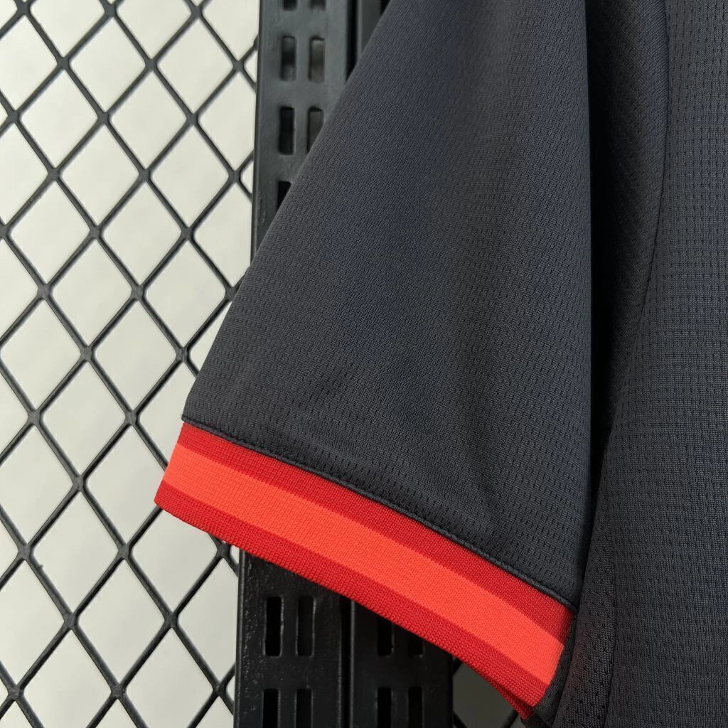 Detalle de la manga de la camiseta AC Milan 26-27 3ª equipación con tejido negro texturizado y remate en tonos rojos