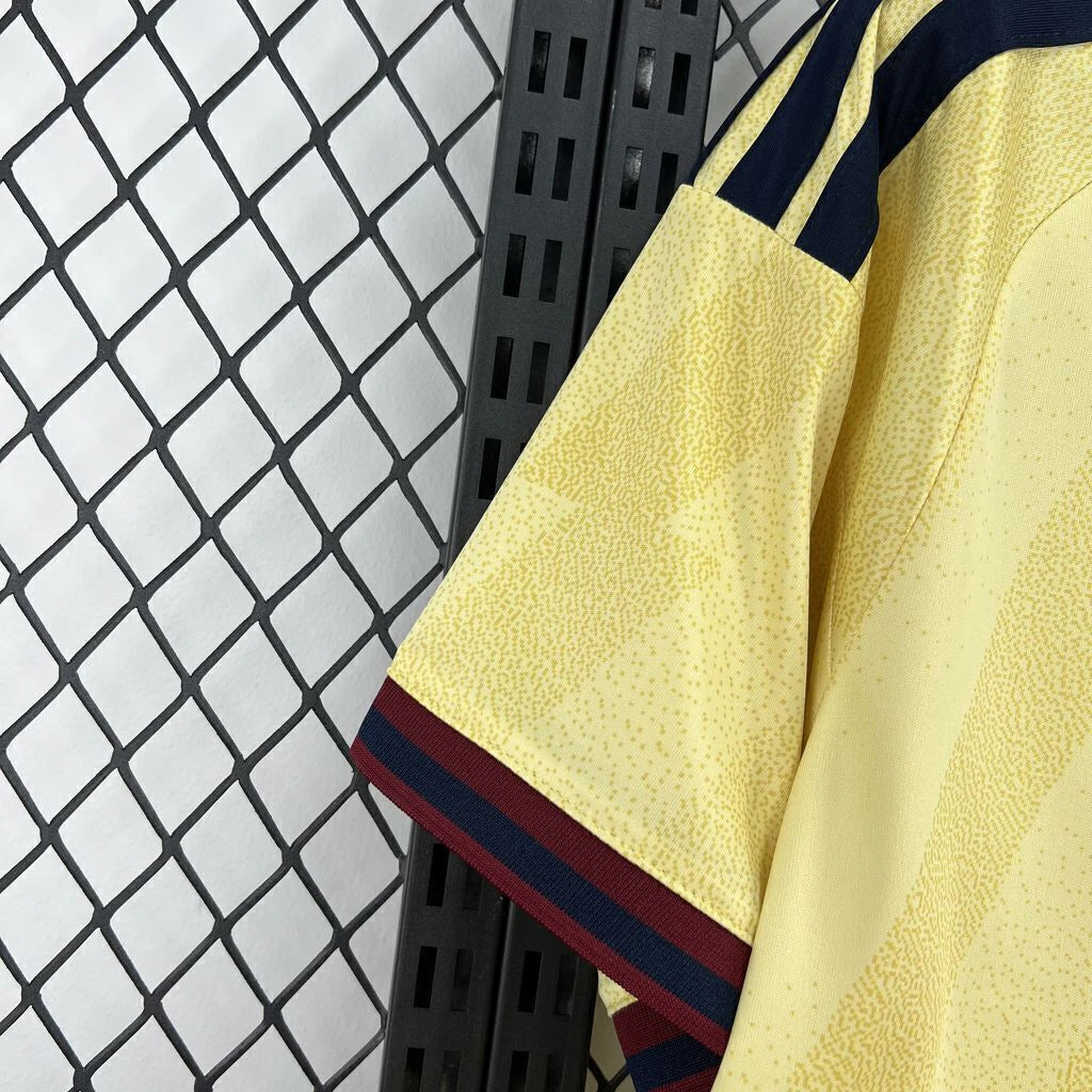Detalle de la manga de la camiseta Arsenal 26-27 tercera equipación con patrón tonal amarillo y remate granate y azul marino