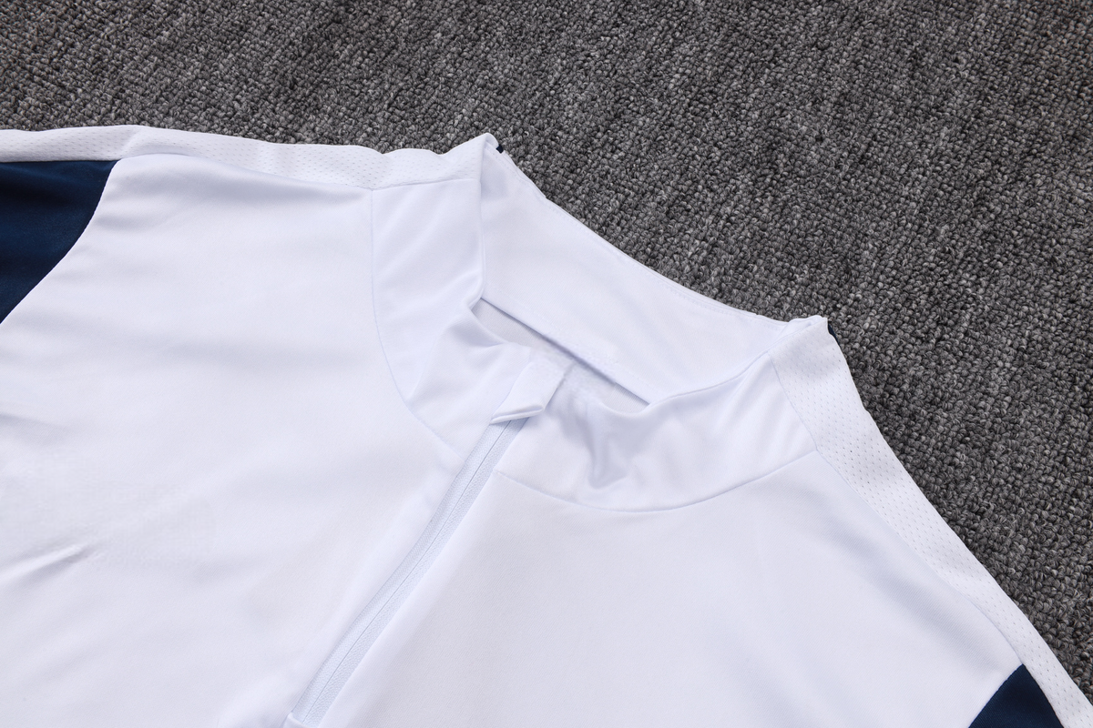 Detalle del cuello alto, media cremallera y panel azul marino de la parte superior del chándal PSG 26-27 Modelo 1