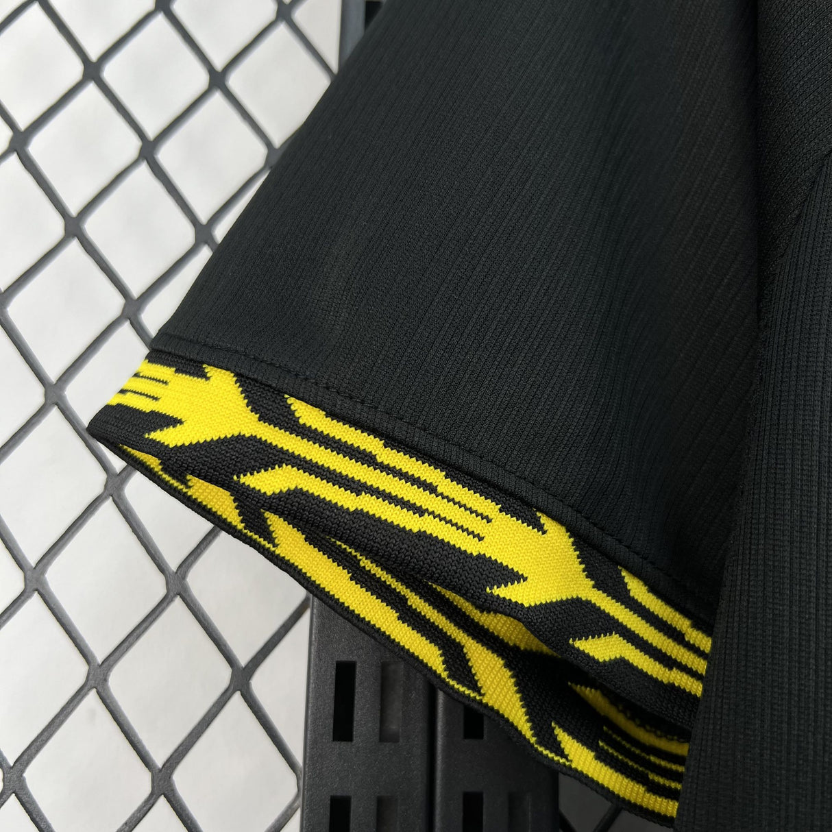Detalle del puño de la camiseta Chelsea 26-27 visitante, con ribete amarillo de diseño gráfico sobre fondo negro