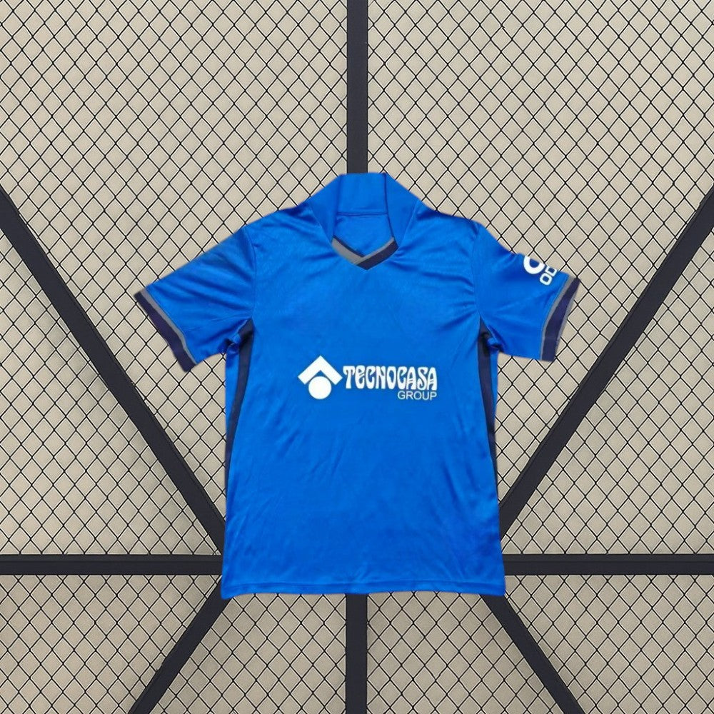 Vista frontal alternativa de la camiseta Getafe 26-27 local, con base azul, ribetes oscuros en cuello y mangas y paneles laterales en contraste