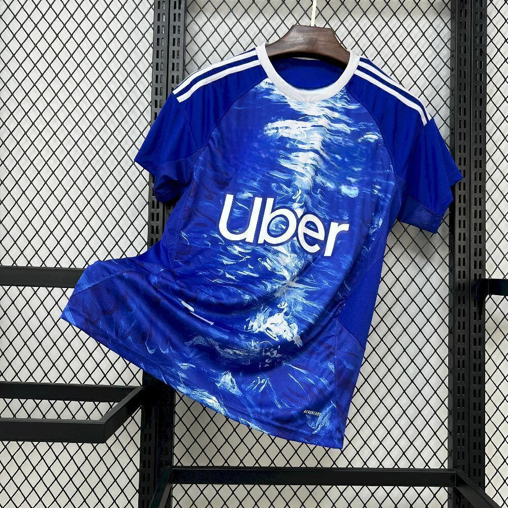 Vista frontal de la Camiseta Como 25-26 local azul con cuello blanco y estampado abstracto en el frontal