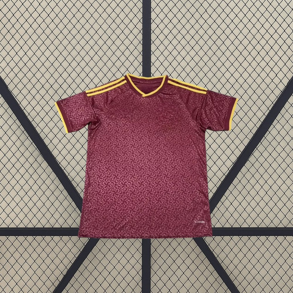 Vista frontal de la camiseta España 26-27 edición especial campeones 2026 granate con patrón tonal, detalles dorados y dos estrellas de bicampeones