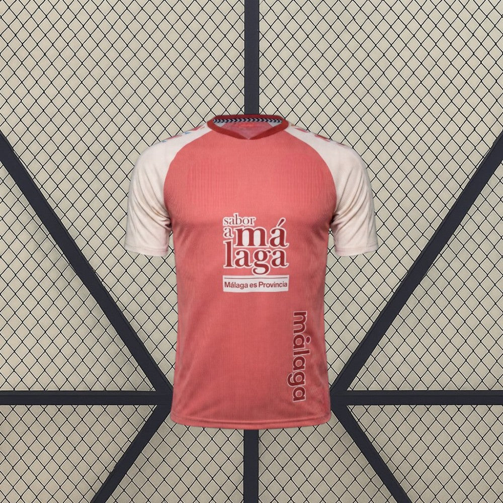 Vista frontal de la camiseta Málaga 26-27 visitante en color coral, con mangas crema, cuello oscuro y textura vertical en el tejido