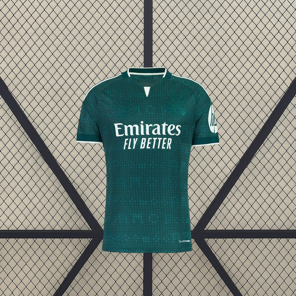 Vista frontal de la camiseta R.M. 26-27 visitante en verde oscuro, con patrón tonal, cuello abierto con ribete blanco y manga corta