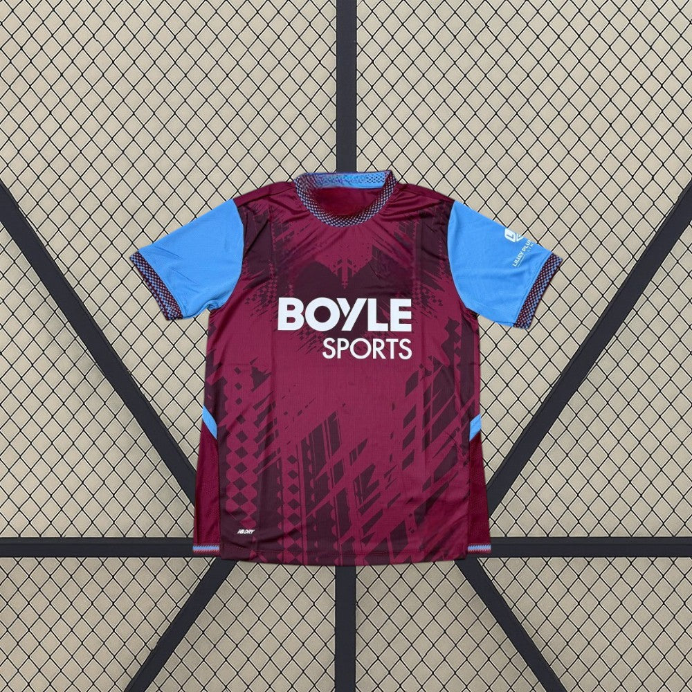 Vista frontal de la camiseta West Ham 26-27 Local granate con patrón gráfico tonal, mangas azul celeste y cuello redondo