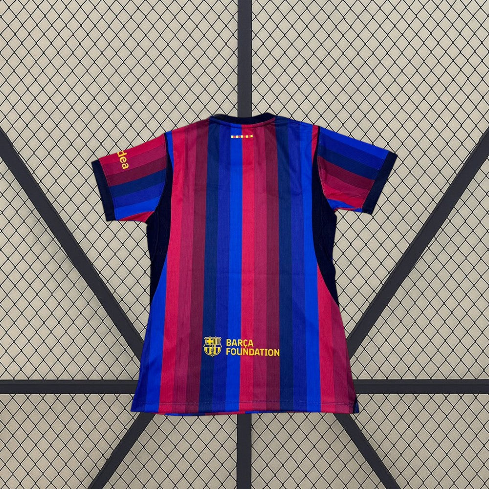 Vista trasera de la Camiseta Barcelona mujer 26-27 local con franjas azul y grana y detalle amarillo inferior
