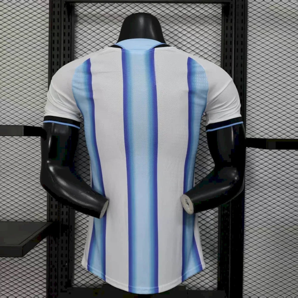Vista trasera de la camiseta Argentina 26-27 local versión Player, con franjas blancas y celestes, cuello celeste y puños negros