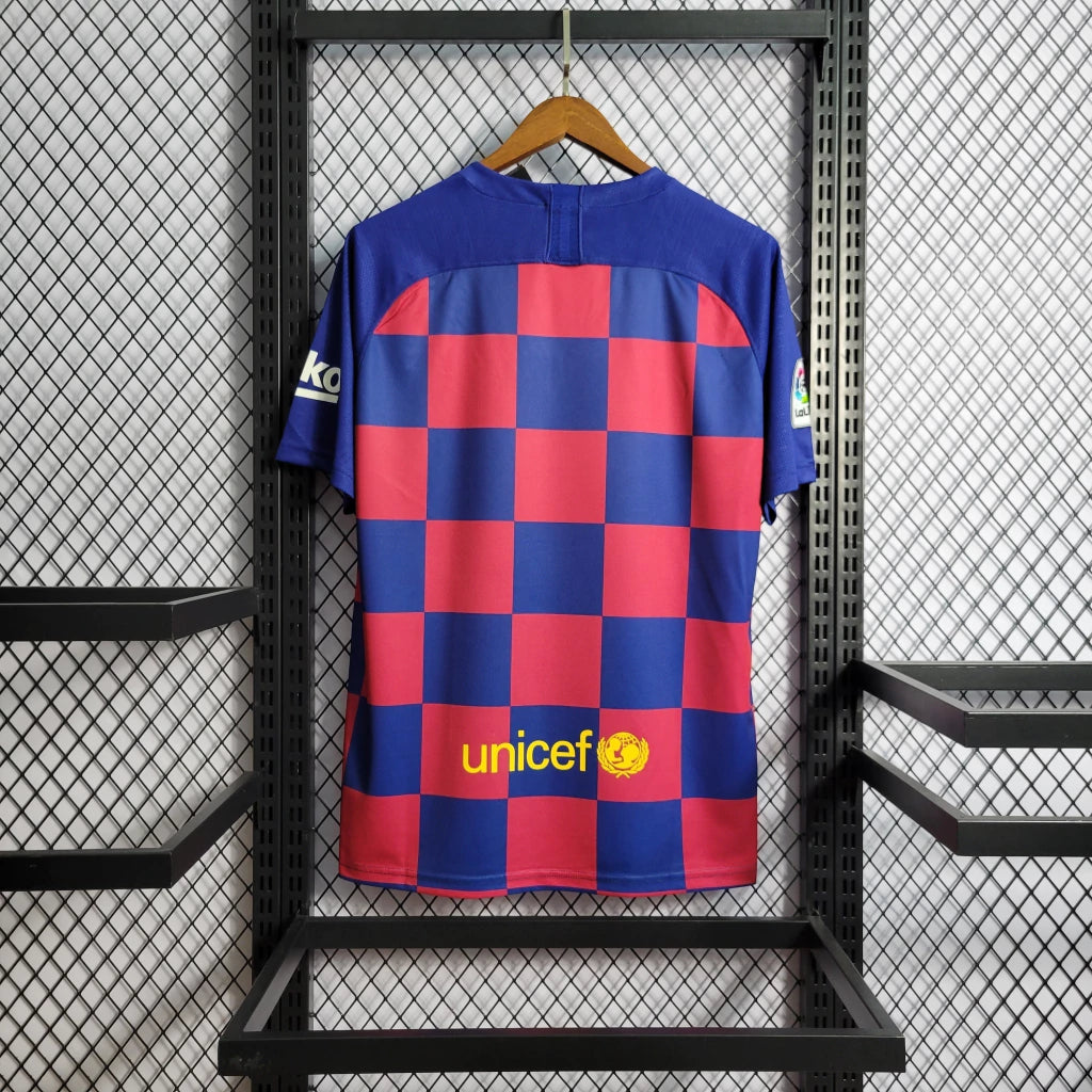 Vista trasera de la camiseta Barcelona 19-20 local versión retro con patrón de cuadros azules y granates y panel superior azul