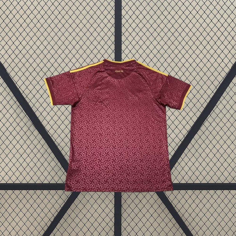 Vista trasera de la camiseta España 26-27 edición especial campeones 2026 granate con patrón tonal y detalles dorados en hombros y mangas