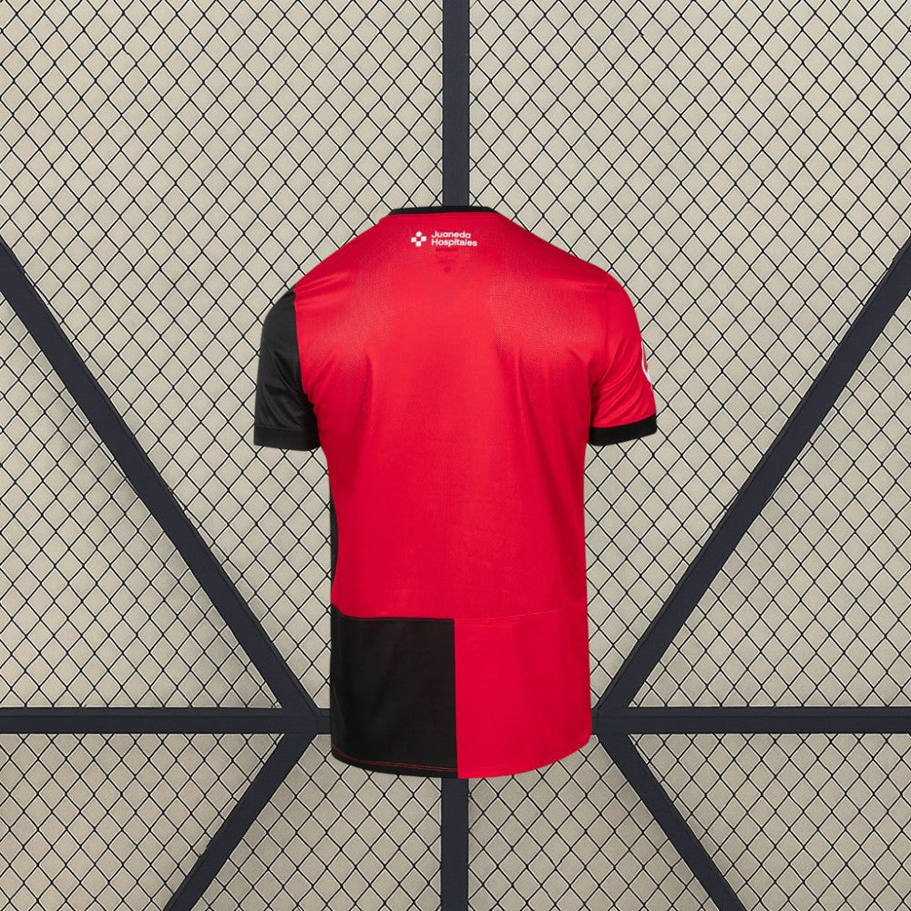 Vista trasera de la camiseta Mallorca 26-27 local, con base roja, manga negra y panel inferior en rojo y negro