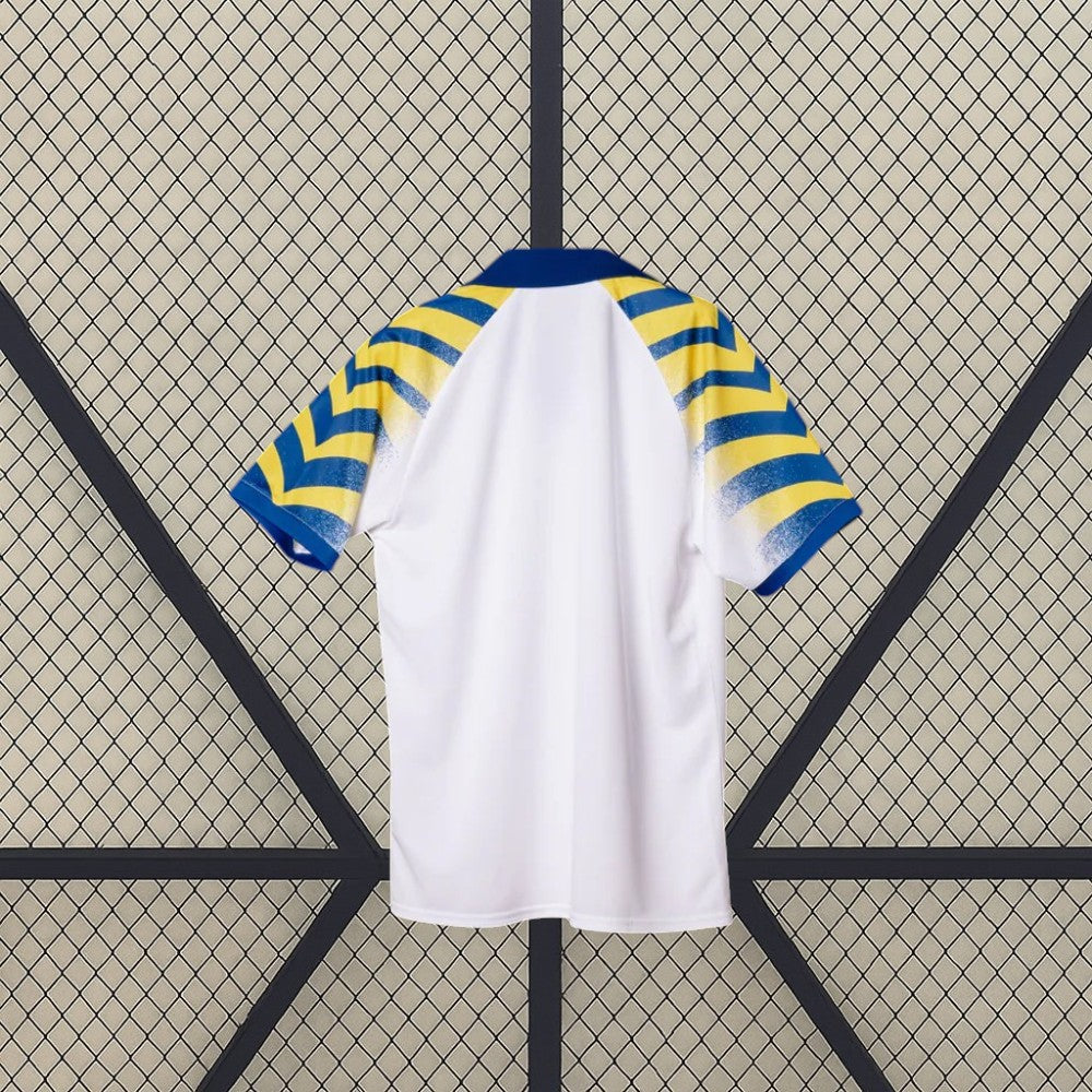 Vista trasera de la camiseta Parma 25-26 tercera equipación mostrando la espalda lisa blanca y las mangas con franjas azules y amarillas
