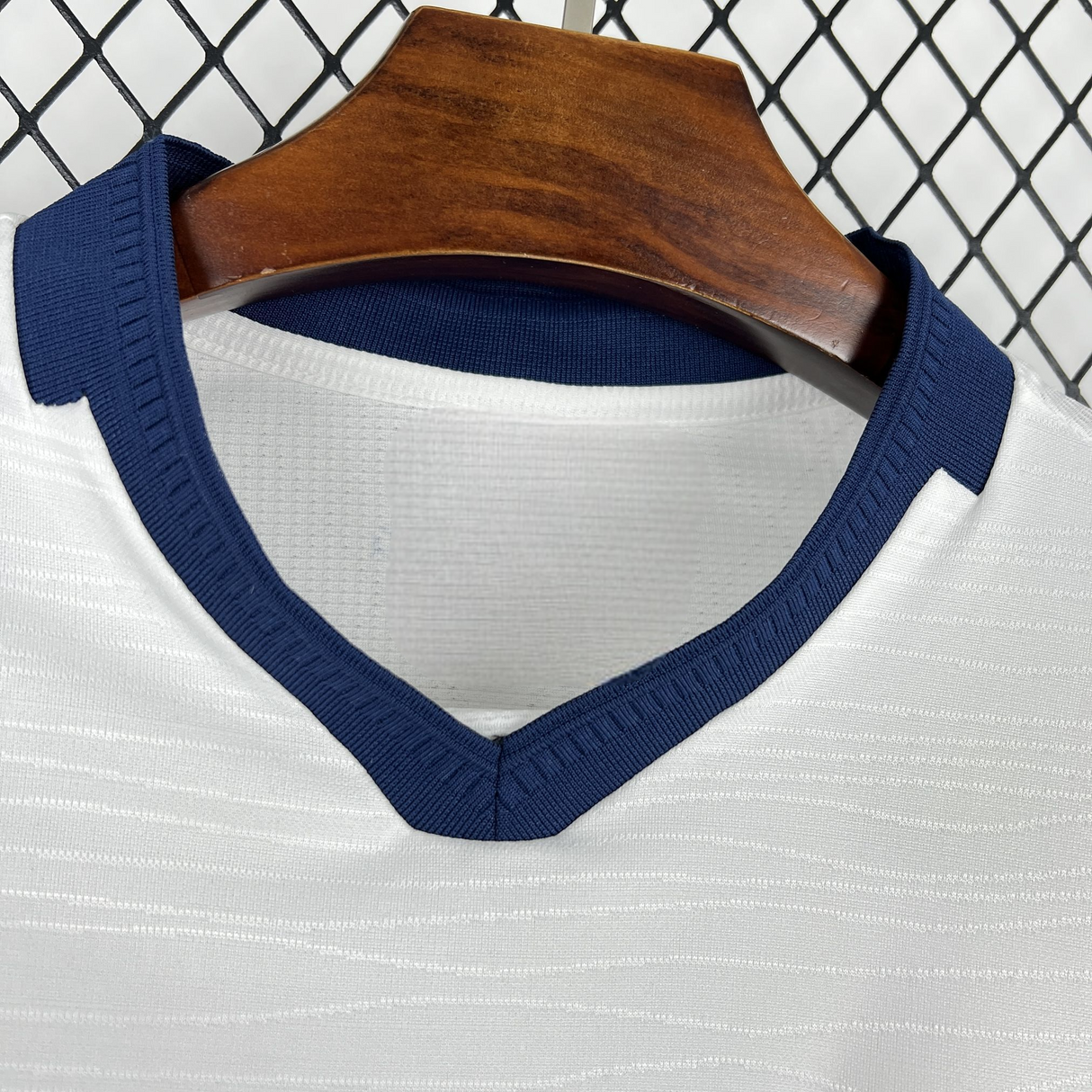 Detalle del cuello en V azul marino de la camiseta Ecuador 26-27 tercera equipación