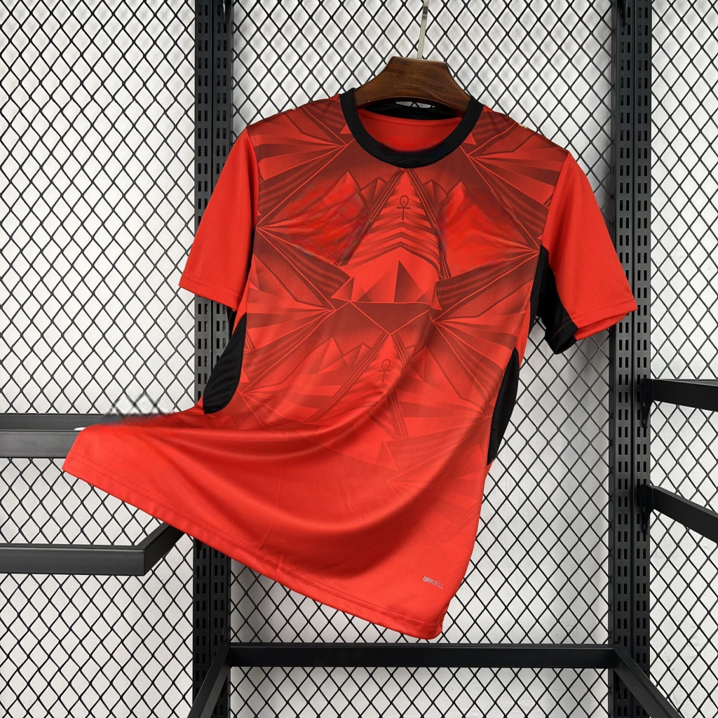 Camiseta Egipto 26-27 local vista frontal en color rojo con gráfico geométrico y cuello negro