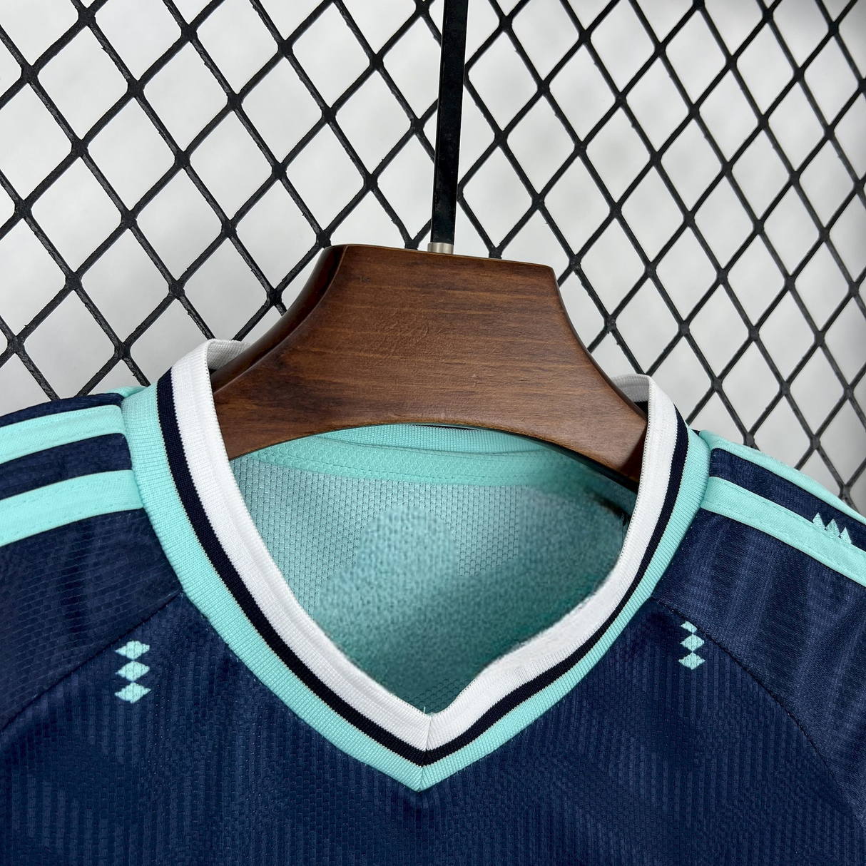 Detalle del cuello en pico de la Equipación Alemania 26-27 Visitante Niño Mundial 2026