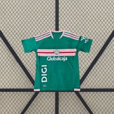 Camiseta Albacete 26-27 Visitante extendida de frente en verde con franja rosa y granate en el pecho y detalles rosas en los hombros