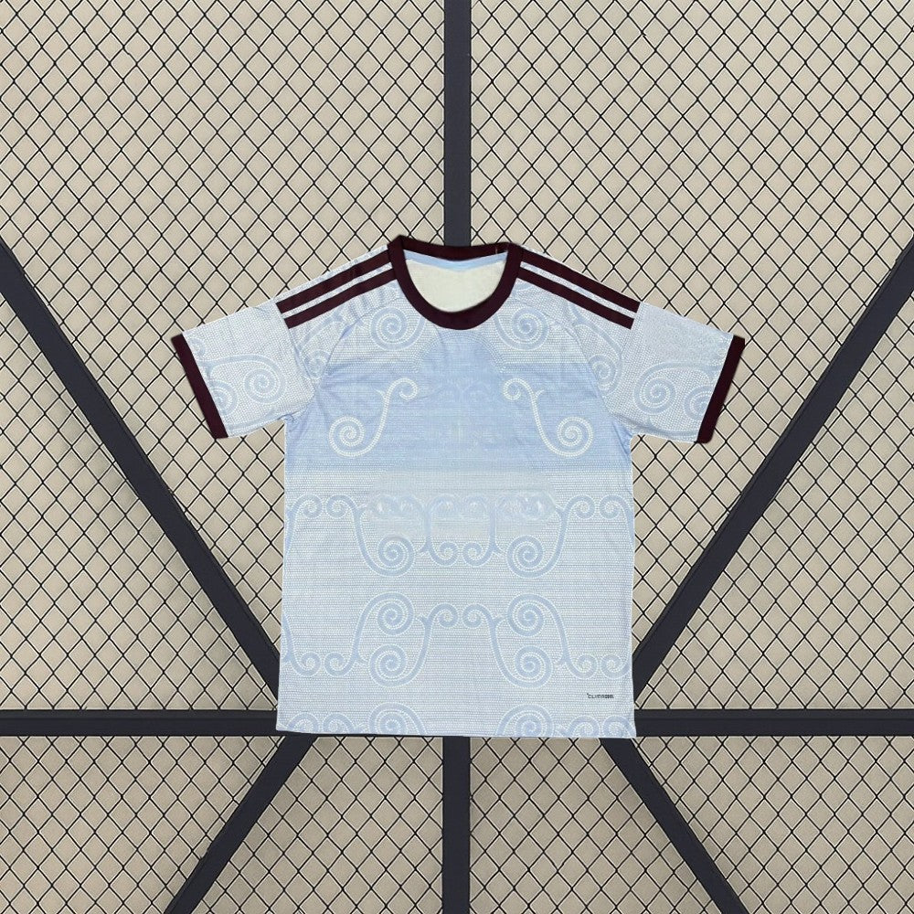 Camiseta Aston Villa 26-27 tercera equipación vista frontal en azul celeste con patrón ornamental tonal, cuello granate y detalles claros en hombros