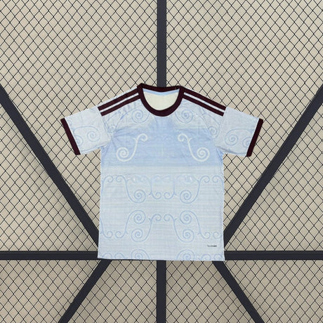 Camiseta Aston Villa 26-27 tercera equipación vista frontal en azul celeste con patrón ornamental tonal, cuello granate y detalles claros en hombros