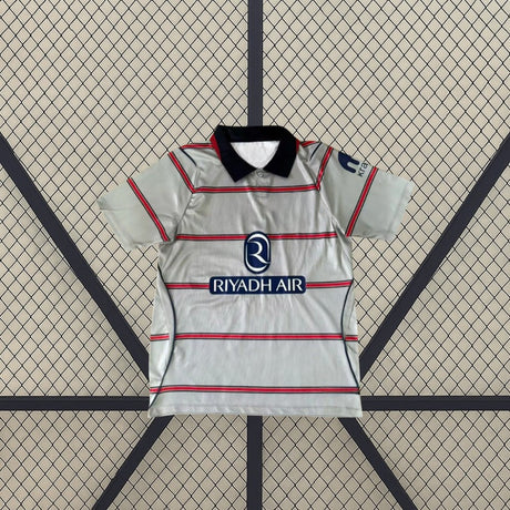 Camiseta Atlético de Madrid 26-27 3ª equipación extendida de frente con base gris, franjas horizontales y cuello tipo polo azul marino