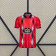 Camiseta Celta de Vigo 26-27 tercera equipación vista frontal en rojo con patrón de rombos azul marino y azul claro y cuello tipo polo