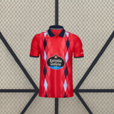 Camiseta Celta de Vigo 26-27 tercera equipación vista frontal en rojo con patrón de rombos azul marino y azul claro y cuello tipo polo