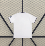 Camiseta Como 26-27 visitante vista trasera en blanco con cuello azul marino y acabado limpio