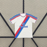 Camiseta Crystal Palace 26-27 local vista frontal completa con base blanca, diseño diagonal rojo y azul y textura tonal