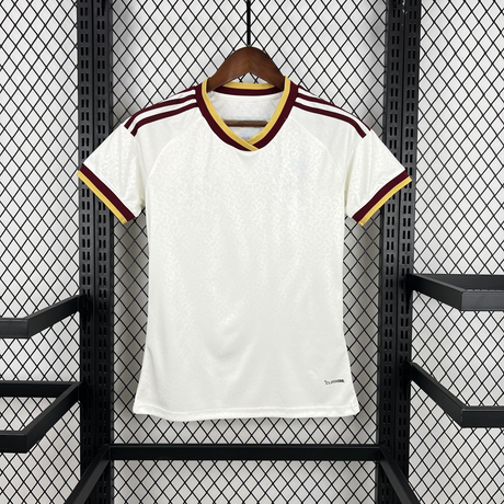 Camiseta España 26-27 visitante mujer vista frontal en color blanco con patrón tonal, cuello en pico granate y amarillo y detalles granates en los hombros