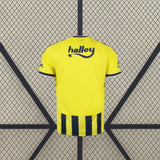 Camiseta Fenerbahçe 26-27 local vista trasera en amarillo con detalles azul marino en mangas y franjas en la zona inferior