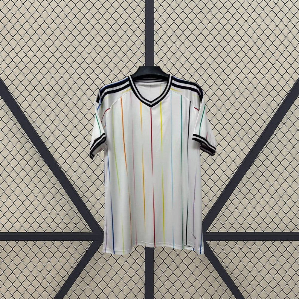 Camiseta Japón 26-27 visitante Mundial 2026 vista frontal en blanco con líneas verticales multicolor, cuello en V negro y puños oscuros