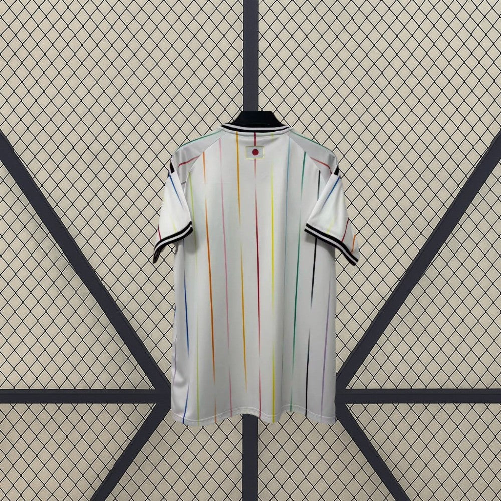 Camiseta Japón 26-27 visitante Mundial 2026 vista trasera en blanco con líneas verticales multicolor, detalles negros y bandera de Japón