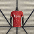 Camiseta Liverpool 26-27 local Player Version vista frontal en rojo con patrón geométrico claro, cuello redondo y remates blancos