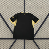 Camiseta Manchester City 26-27 visitante vista trasera en negro con paneles laterales dorados, patrón de abejas en mangas y detalle en la nuca