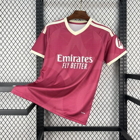 Camiseta R.M. 26-27 tercera equipación vista frontal en rosa oscuro con patrón geométrico tonal, cuello en V crema y detalles en los hombros
