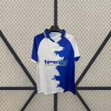 Camiseta Tenerife 26-27 local vista frontal desplegada con diseño asimétrico blanco y azul, cuello con contraste y efecto de pincelada