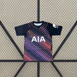 Camiseta Tottenham 26-27 visitante vista frontal en azul marino con estampado diagonal multicolor en tonos rosa, morado y naranja