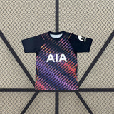Camiseta Tottenham 26-27 visitante vista frontal en azul marino con estampado diagonal multicolor en tonos rosa, morado y naranja
