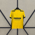 Camiseta Villarreal 26-27 local en amarillo con patrón tonal y detalles azul marino en hombros, mangas y laterales. Ideal para animar, vestir o coleccionar.