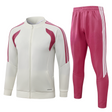 Chándal R.M. 26-27 modelo 5 vista frontal con chaqueta crema de cremallera completa y pantalón rosa con franjas laterales