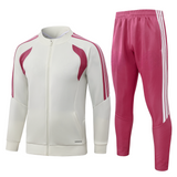 Chándal R.M. 26-27 modelo 5 vista frontal con chaqueta crema de cremallera completa y pantalón rosa con franjas laterales
