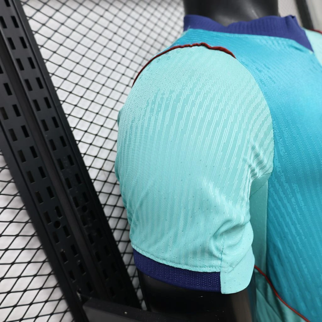 Detalle de hombro y manga de la camiseta Barcelona 26-27 tercera equipación Player con tejido texturizado, puño azul marino y ribete rojo