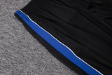 Detalle de la cintura elástica y franja lateral azul con ribete blanco del pantalón negro del chándal Atlético de Madrid 26-27 Modelo 1