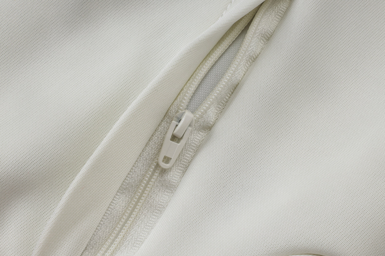 Detalle de la cremallera blanca y del tejido de la chaqueta del chándal R.M. 26-27 modelo 5