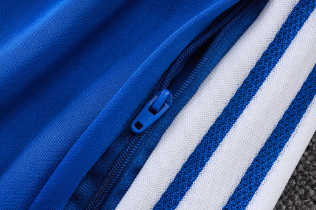 Detalle de la cremallera lateral y las franjas blancas del pantalón del chándal Juventus 26-27 en color azul