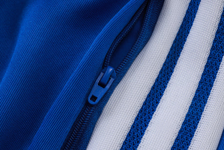 Detalle de la cremallera y las franjas laterales del pantalón del chándal Juventus 26-27 en color azul y blanco
