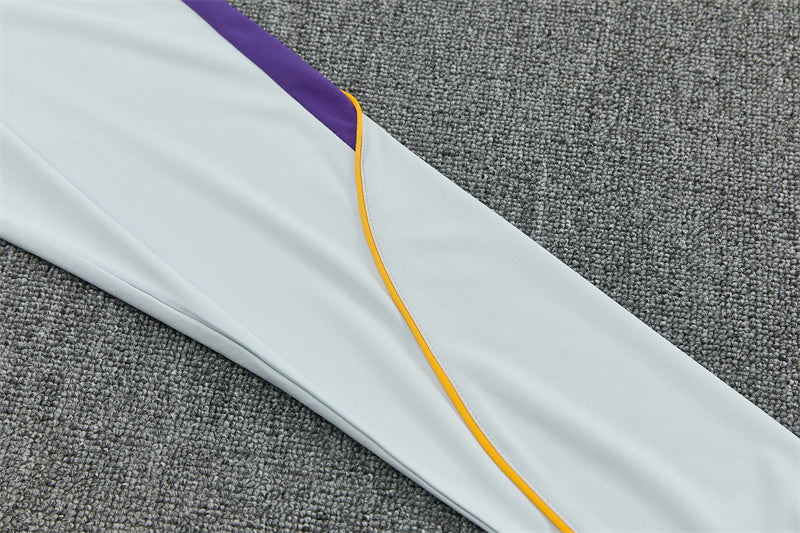 Detalle de la manga azul claro del chándal Barcelona 26-27 con panel morado y fino ribete naranja