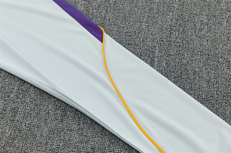 Detalle de la manga azul claro del chándal Barcelona 26-27 con panel morado y fino ribete naranja